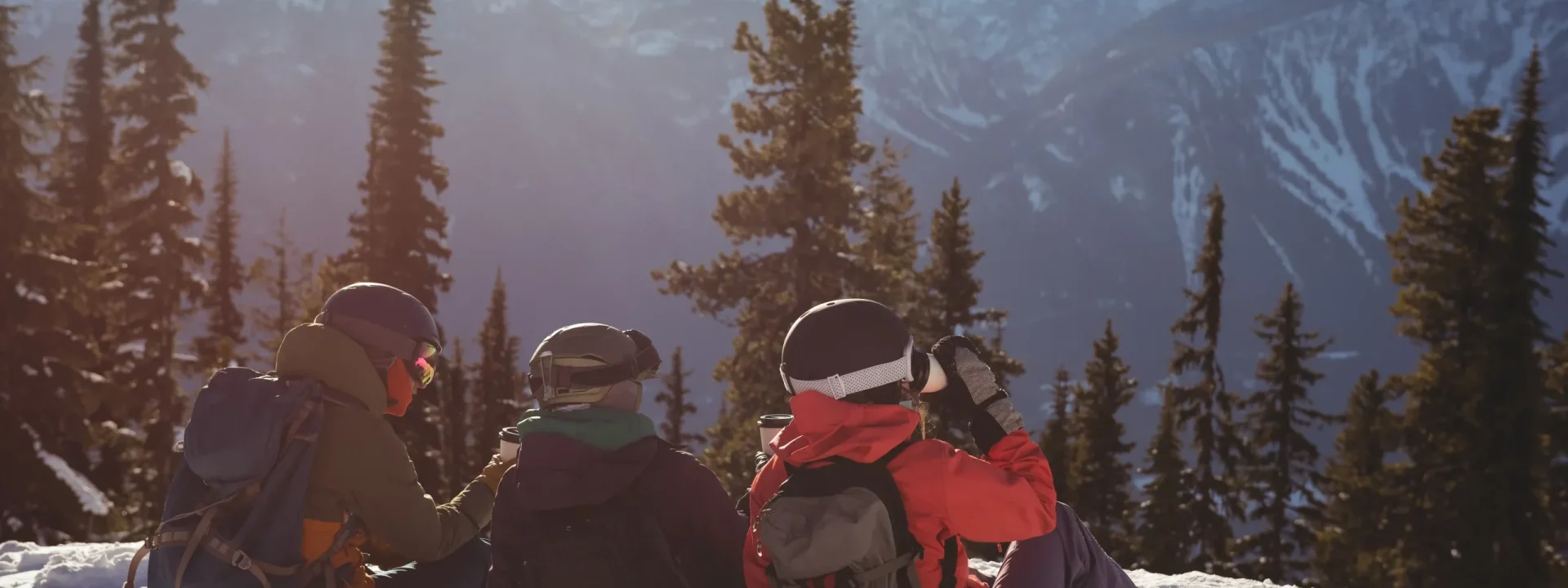 tres-esquiadores-relajandose-en-la-montana-cubierta-de-nieve_11zon